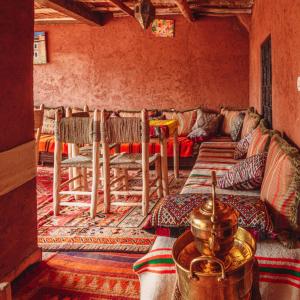 イムリルにあるAtlas Kasbah Lodgeのリビングルーム(ソファ、いくつかの椅子付)