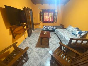 a living room with a couch and a tv at Cabaña Emilia in San Javier
