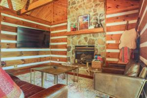 a living room with a fireplace in a log cabin at Family Home with Porch and Center Hill Lake Views! in Silver Point +19 photos
