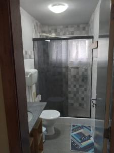uma casa de banho com um chuveiro, um WC e um lavatório. em Temporada Ilheus na Praia dos Milionarios Kitnet em Ilhéus