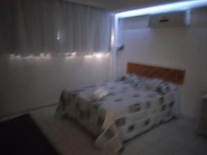 um quarto com uma cama num quarto em Temporada Ilheus na Praia dos Milionarios Kitnet em Ilhéus