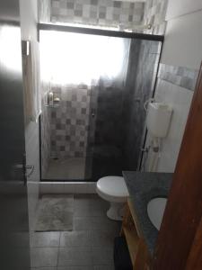 uma casa de banho com um chuveiro, um WC e um lavatório. em Temporada Ilheus na Praia dos Milionarios Kitnet em Ilhéus