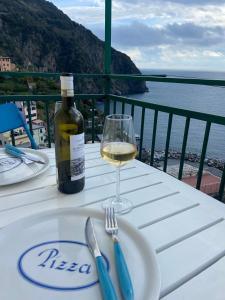 - une bouteille de vin et un verre sur une table dans l'établissement LASOMMO 1, à Riomaggiore