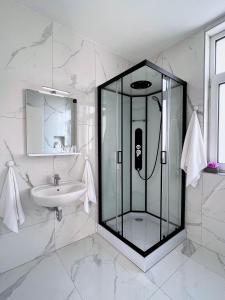 a bathroom with a glass shower and a sink at Villa Riverside in Ljubljana
