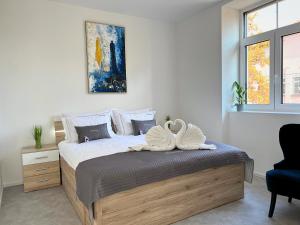 Un dormitorio con una cama con dos cisnes. en Villa Riverside, en Liubliana