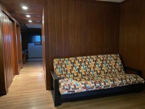 a couch in a room with a wooden wall at Hotel Contadero Suites y Villas in Mexico City