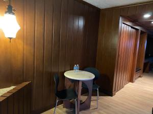 a table and chairs in a room with wooden walls at Hotel Contadero Suites y Villas in Mexico City