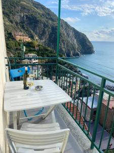 d'une table et de chaises blanches sur un balcon donnant sur l'océan. dans l'établissement LASOMMO 1, à Riomaggiore