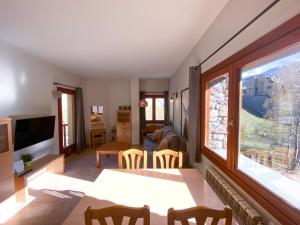 uma sala de estar com uma mesa e uma grande janela em Disfruta De La Naturaleza - Vistas al Rio - Luz Natural - 6pax em Canillo