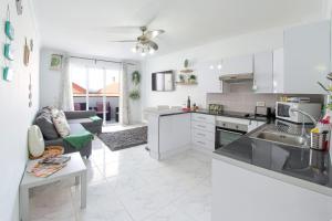 a white kitchen with a couch and a table at Gorgeous Los Diamantes Home in Los Cristianos