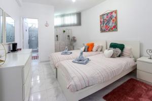 a white room with two beds and a kitchen at Gorgeous Los Diamantes Home by LoveTenerife in Los Cristianos