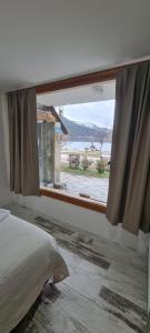 a bedroom with a window with a view of the ocean at Puerto Lacar Lodge SMARG in San Martín de los Andes