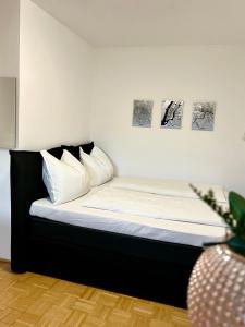 een bed in een kamer met twee foto's aan de muur bij urbanstays Linz Landstraße - city center - near casino in Linz