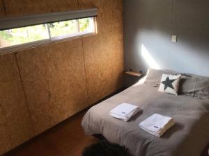 1 dormitorio con 1 cama con toallas en Casa de montaña en Potrerillos