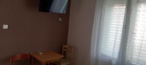 a room with a table and a window with a television at Pakovo Apartments Andrija in Tivat