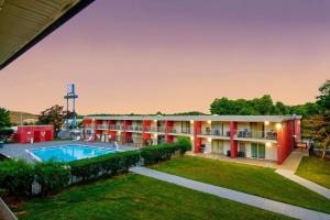 an exterior view of a hotel with a pool and yard at Motel 6-Gainesville, GA in Gainesville