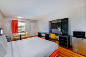 Habitación de hotel con cama y escritorio con sillas en Motel 6-Gainesville, GA, en Gainesville