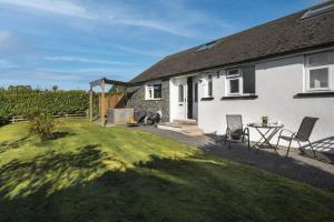 a house with a yard with a table and chairs at Scar View - Getaway for Two in Underbarrow