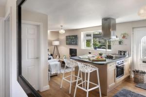 a kitchen with a counter and stools in a room at Scar View - Getaway for Two in Underbarrow