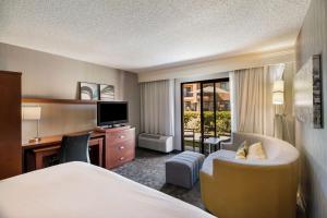 a hotel room with a bed and a desk at Sonesta Select Huntington Beach Fountain Valley in Huntington Beach