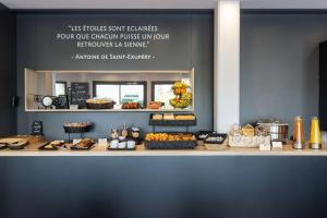 a bakery counter with cakes and pastries on it at Best Western St Exupery Bordeaux Ouest in Eysines