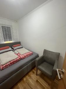 查查克PANDORA APARTMAN CACAK的卧室里有一张床和一把椅子