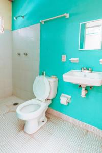 La salle de bains bleue est pourvue de toilettes et d'un lavabo. dans l'établissement Hotel Lekami, à Puerto Escondido