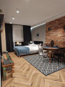 um quarto com uma cama, uma mesa e cadeiras em Arte Apartments - Old Town Gdańsk em Gdansk