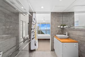 a bathroom with a sink and a large mirror at Baronnet Apartments in Gold Coast