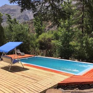 a swimming pool with a chair and a blue umbrella at Cabaña El Ingenio in El Ingenio