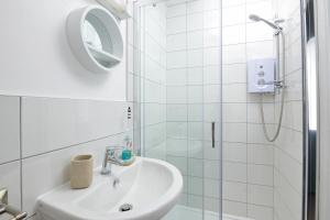 a white bathroom with a sink and a shower at The Seaside Inn in Seaton +16 photos