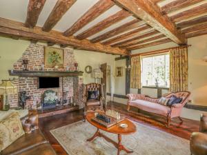 a living room filled with furniture and a fireplace at Waveney Cottage in Diss