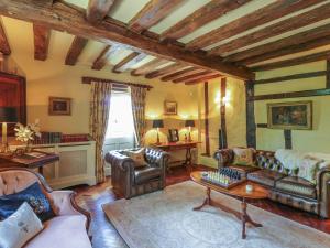 迪斯的住宿－Waveney Cottage，客厅配有皮革家具和桌子