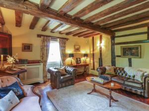 a living room with leather furniture and a table at Waveney Cottage in Diss