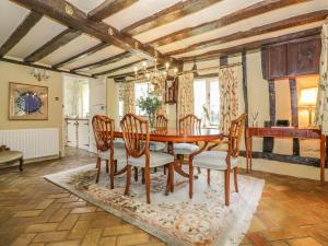 a dining room with a wooden table and chairs at Waveney Cottage in Diss +15 photos
