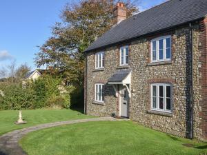 an old brick house with a lawn in front of it at South Glebe in Axminster