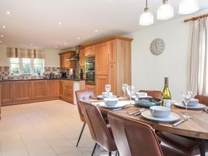 a kitchen and dining room with a wooden table and chairs at South Glebe in Axminster