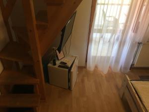 Zimmer mit einer Treppe, einem TV und einem Tisch in der Unterkunft Napsütötte Kehida in Kehidakustány