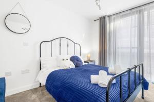 a bedroom with a blue and white bed with a window at Magical - 2Bed Apartment- City Centre-Free Parking in Birmingham