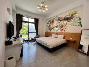 a bedroom with a bed and a desk with a computer at Kenting Peninsula Inn in Kenting