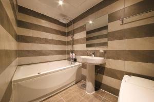 a bathroom with a sink and a tub and a toilet at DUNE45 in Suwon