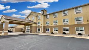 a large building with a parking lot in front of it at Estherville Hotel & Suites in Estherville