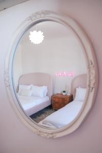 a mirror reflecting a room with two beds and a couch at Casa Mina #4 Central Rio Grande Historic District in El Paso