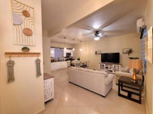 Earthy 2 Story Beach House! في بورتو بيناسكو: غرفة معيشة مع أريكة ومطبخ