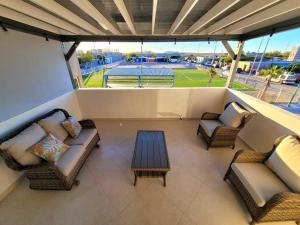 balcón con sofás, mesa y campo de béisbol en Earthy 2 Story Beach House! en Puerto Peñasco