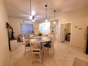 a dining room with a table and chairs and a couch at Earthy 2 Story Beach House! in Puerto Peñasco