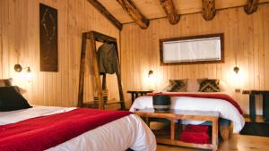 a bedroom with two beds and a table in it at Patagonia East River in Llanada Grande