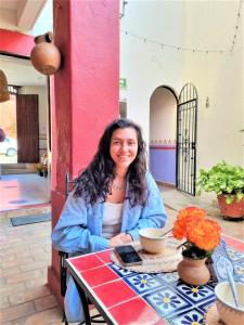 a woman sitting at a table with a cup of coffee at Posada Don Mario in Oaxaca City