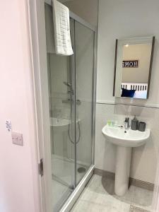 y baño con ducha y lavamanos. en Cambridge Studios and Suites by Tas Accommodations, en Cambridge