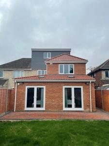 a brick house with white windows and a yard at Cambridge Studios and Suites by Tas Accommodations in Cambridge
